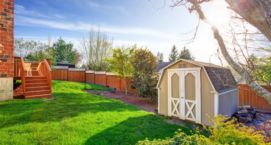 Fenced backyard with storage shed in Kennewick